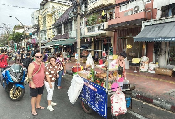 Street food vendor at Wang Lang Market serving Miang Kham and deep-fried pork